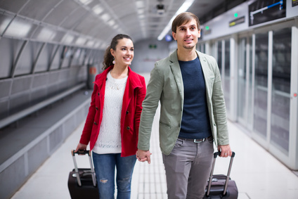 Young passengers with suitcases moving through subway station